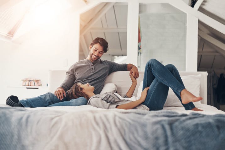 Couple holding hands in bed